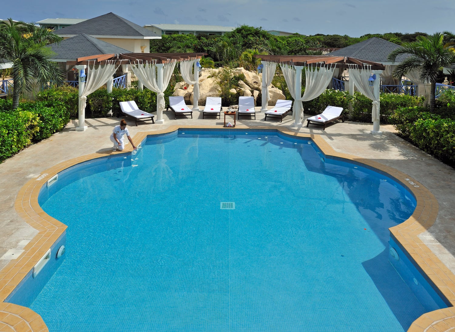 a pool with chairs and a woman sitting in it