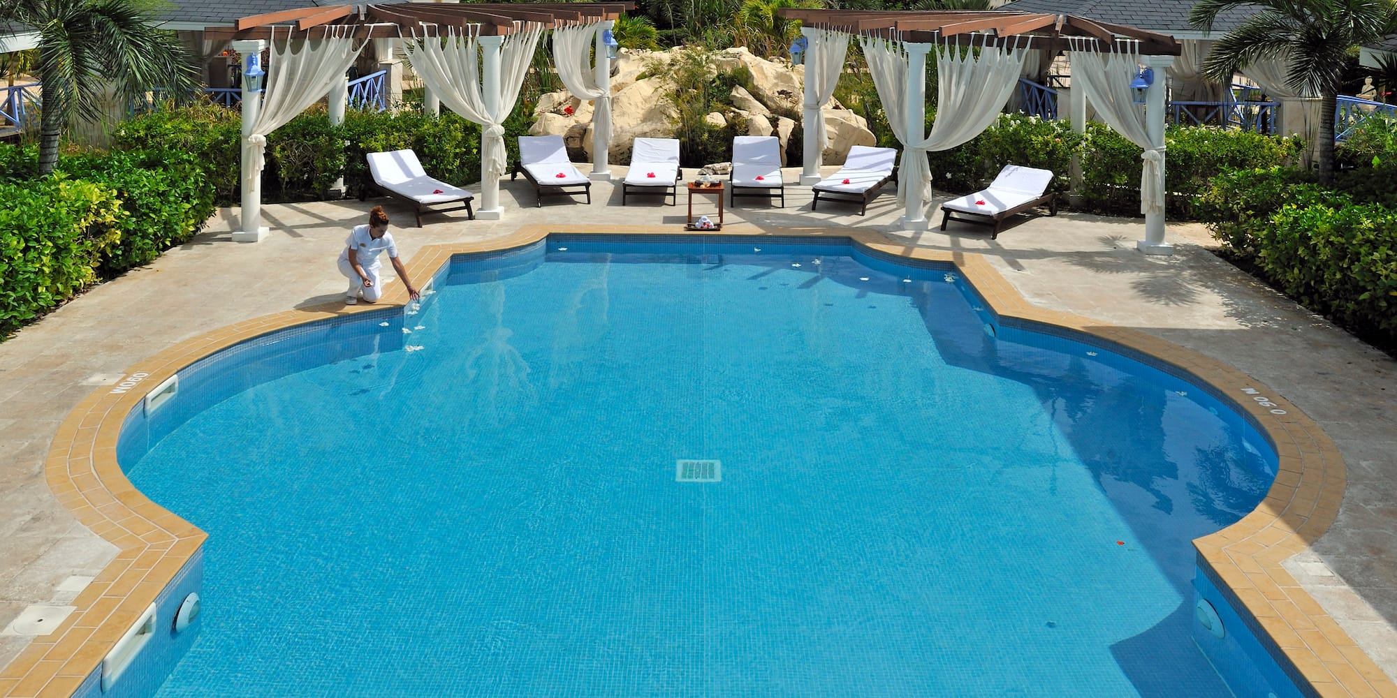 a pool with chairs and a woman sitting in it