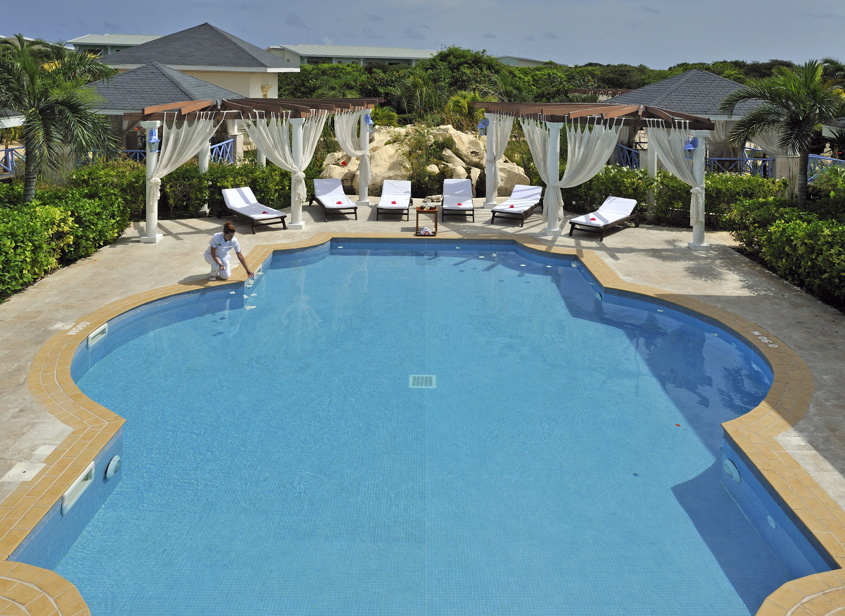 a pool with chairs and a woman sitting in it