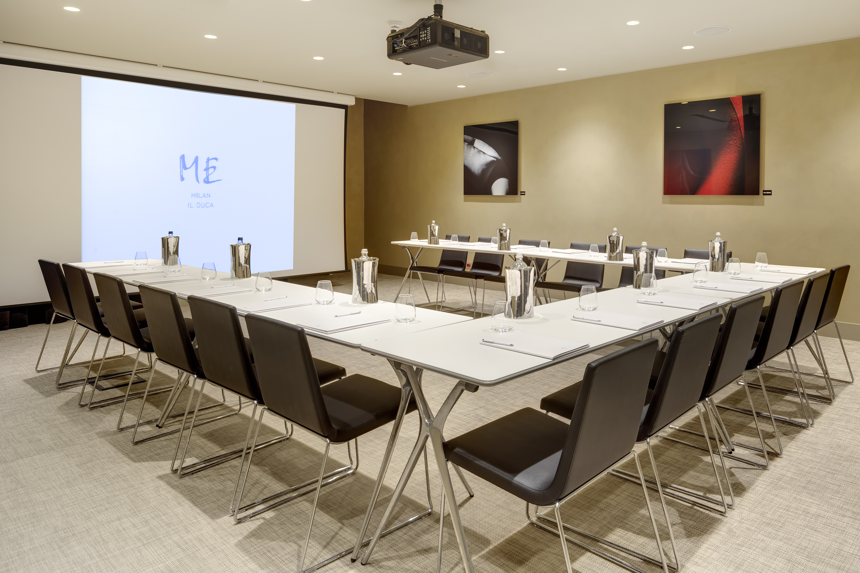U-shaped meeting room with projector screen and ME Milan Il Duca branding.