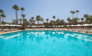 a pool with white umbrellas and palm trees
