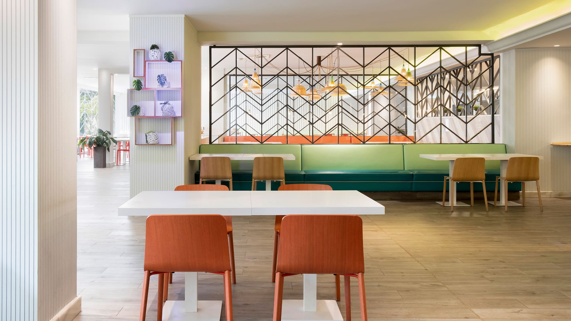 a room with a white table and orange chairs