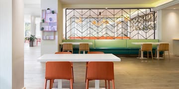 a room with a white table and orange chairs