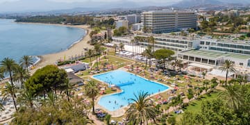 a swimming pool and a beach with palm trees