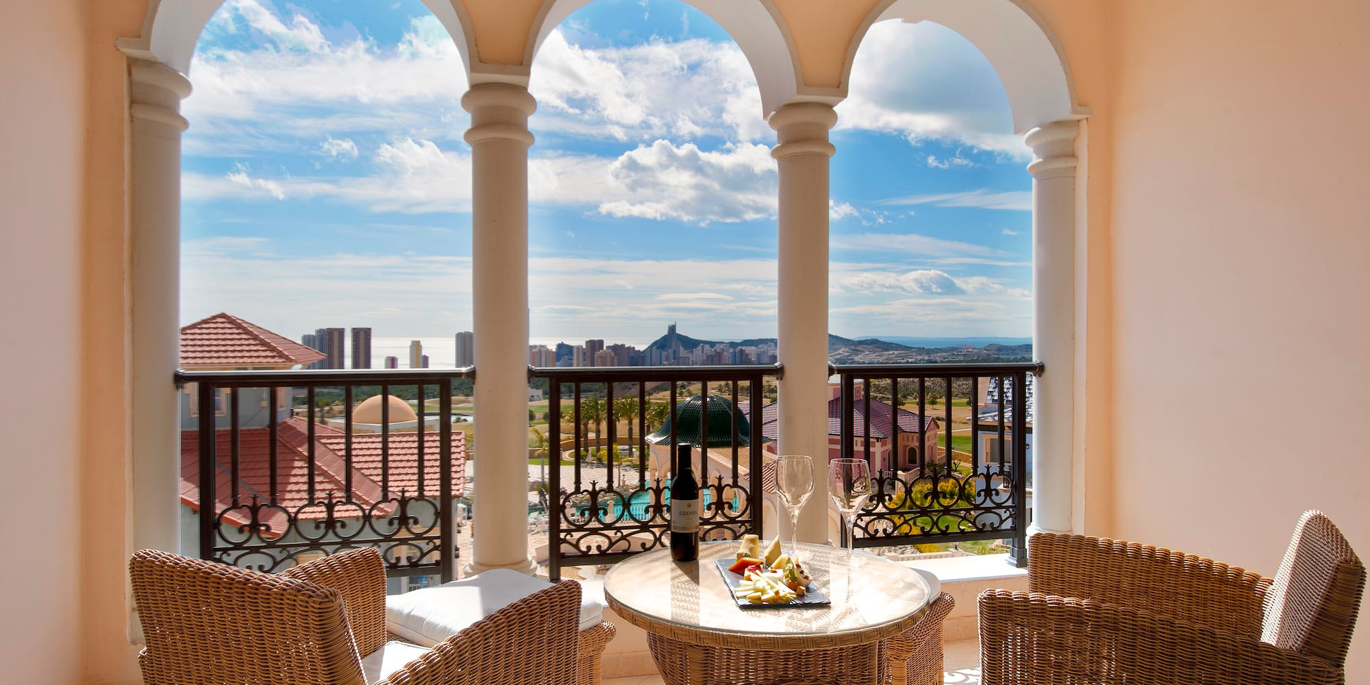 a table and chairs on a balcony with a view of a city