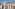 Modern high-rise city skyline with two prominent buildings featuring green roofs.