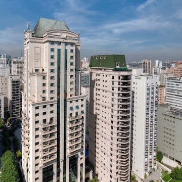 a tall buildings with trees and a blue sky