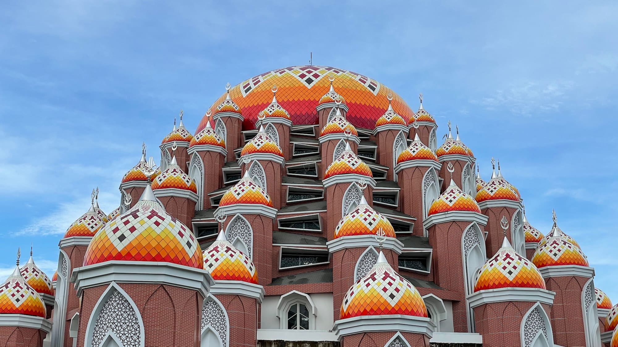 a multicolored building with a dome with Sri Siva Subramaniya temple in the background