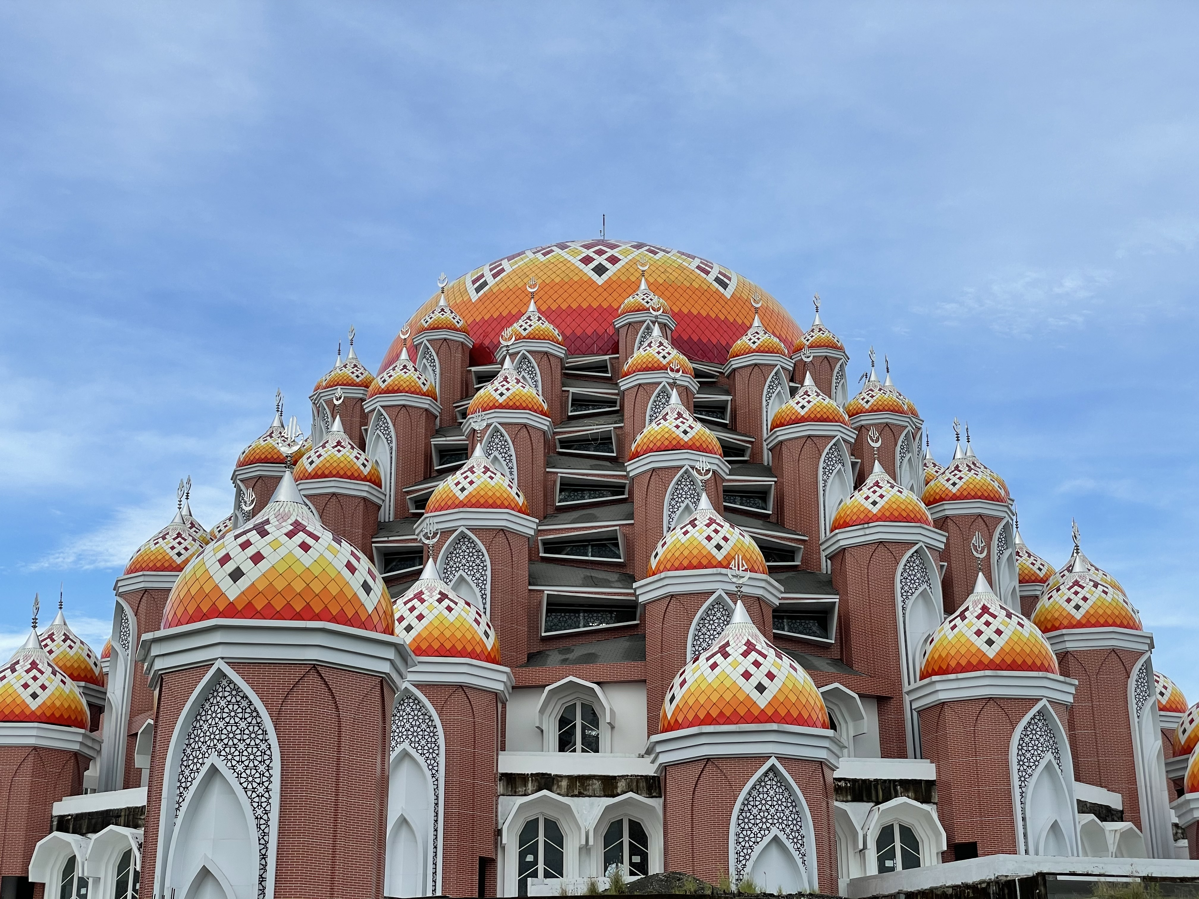 a multicolored building with a dome with Sri Siva Subramaniya temple in the background