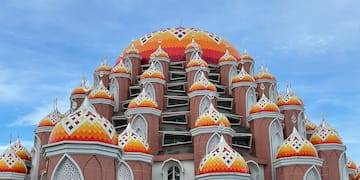 a multicolored building with a dome with Sri Siva Subramaniya temple in the background