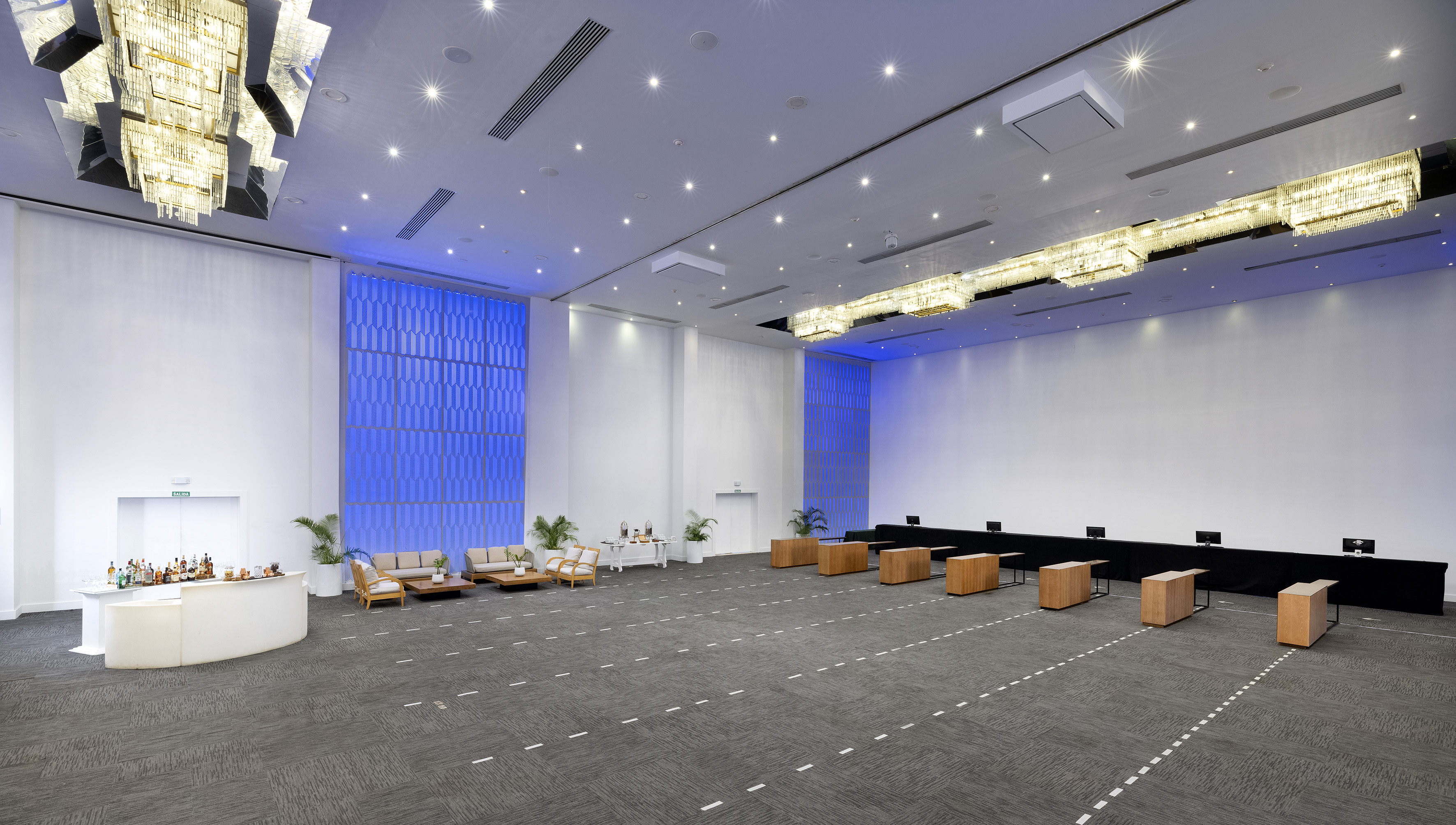 Spacious modern event hall with bar, lounge, and registration tables setup.