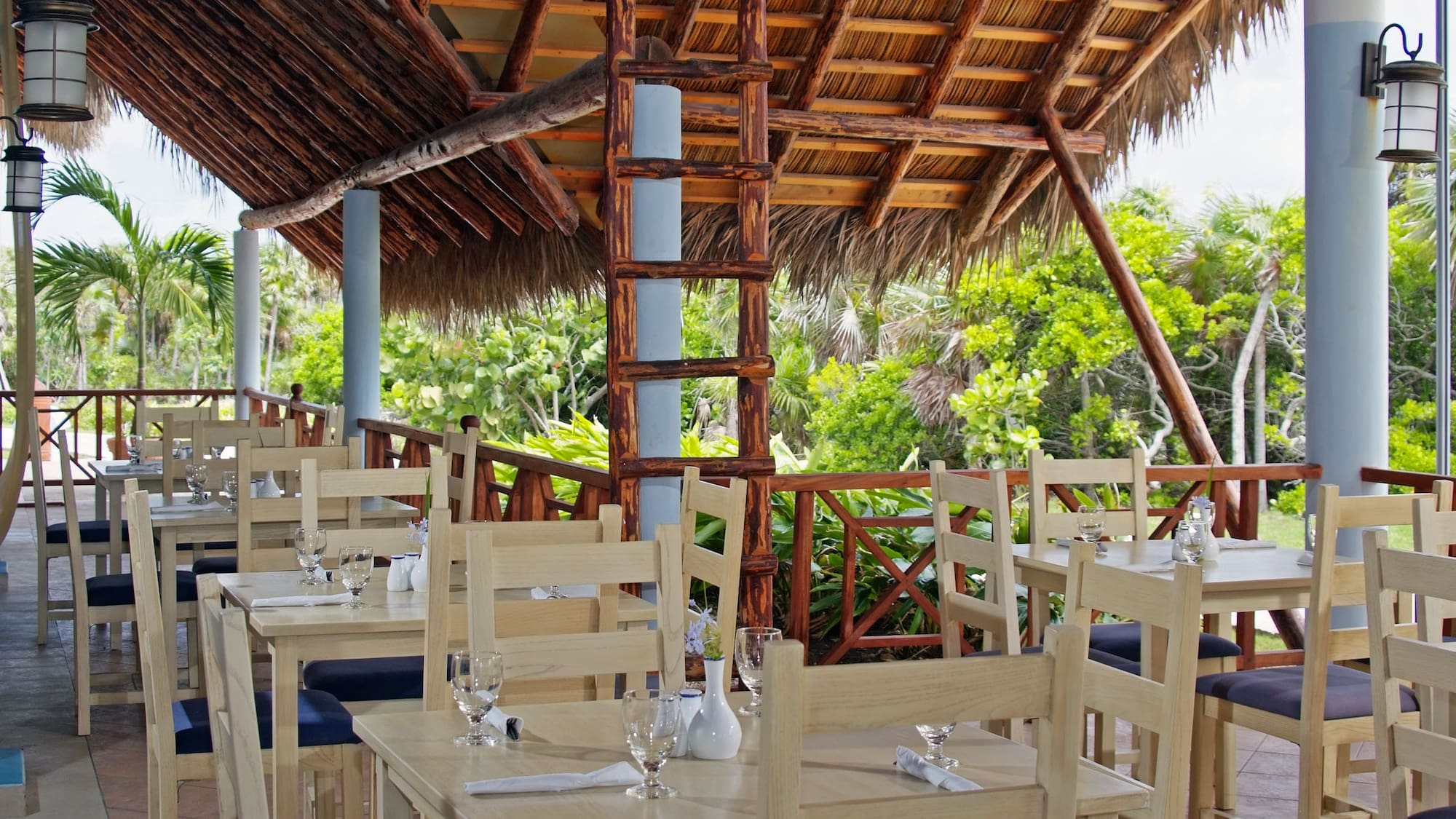 a tables and chairs under a thatched roof