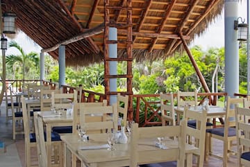 a tables and chairs under a thatched roof