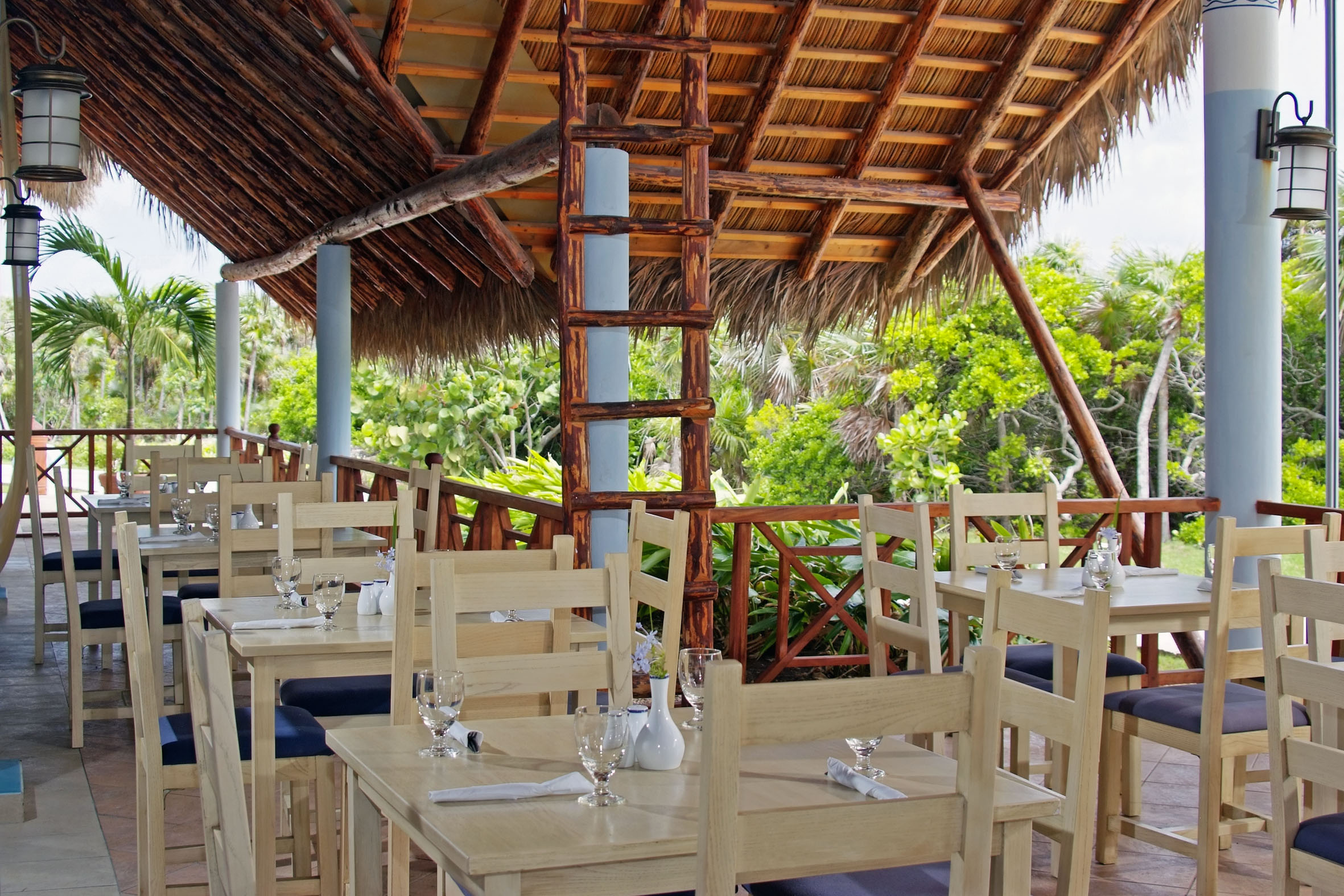 a tables and chairs under a thatched roof
