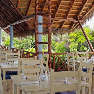 a tables and chairs under a thatched roof