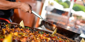 a person cooking food on a large pan