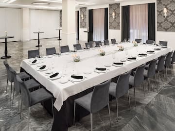 a long table with chairs and plates on it