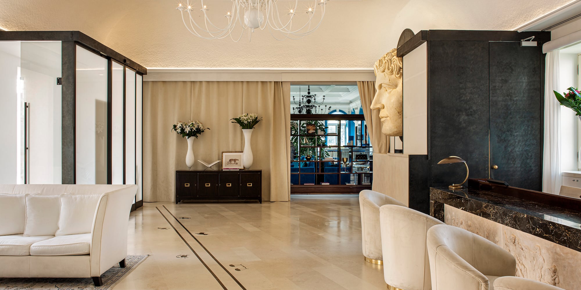 a room with white chairs and a chandelier