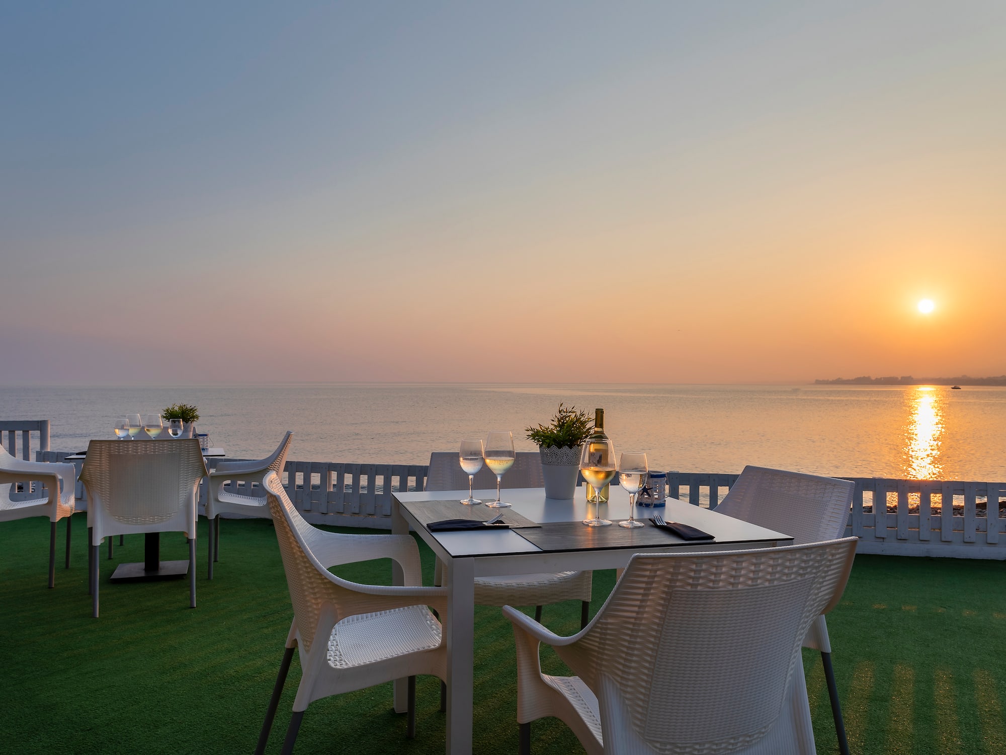a table and chairs on a deck overlooking the ocean