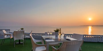 a table and chairs on a deck overlooking the ocean
