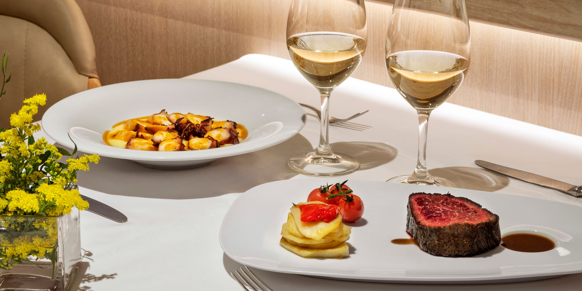 a plate of food and wine glasses on a table