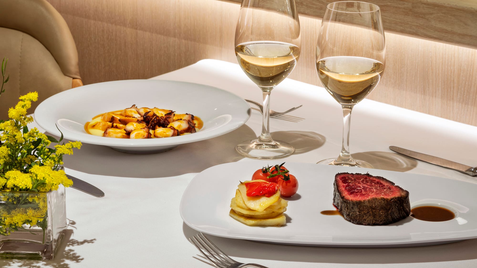 a plate of food and wine glasses on a table