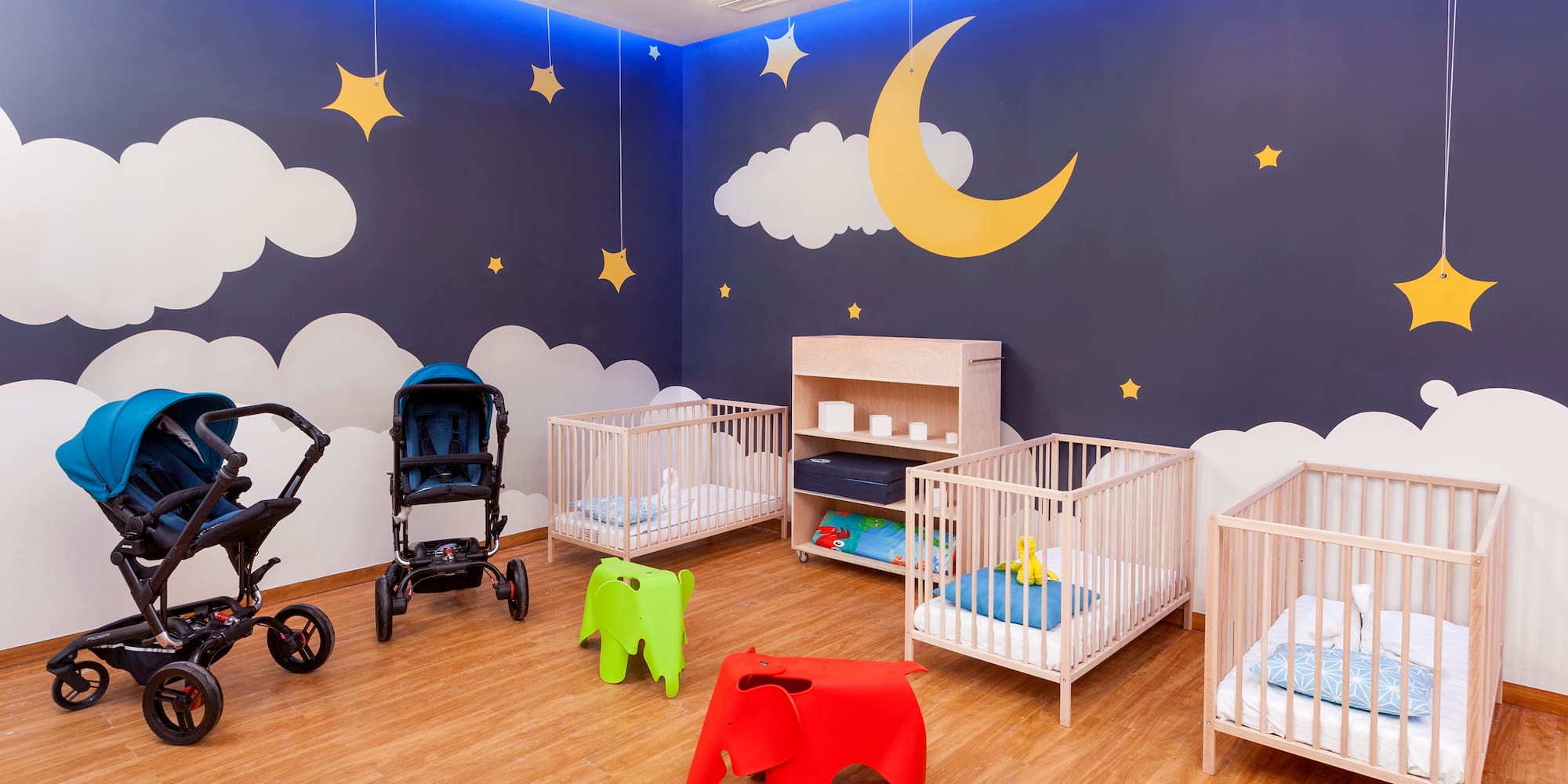 a room with cribs and baby strollers