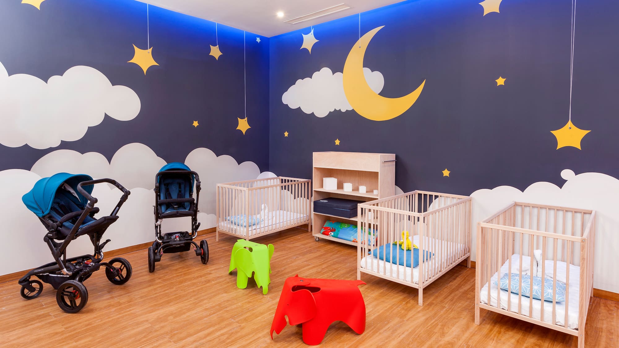 a room with cribs and baby strollers