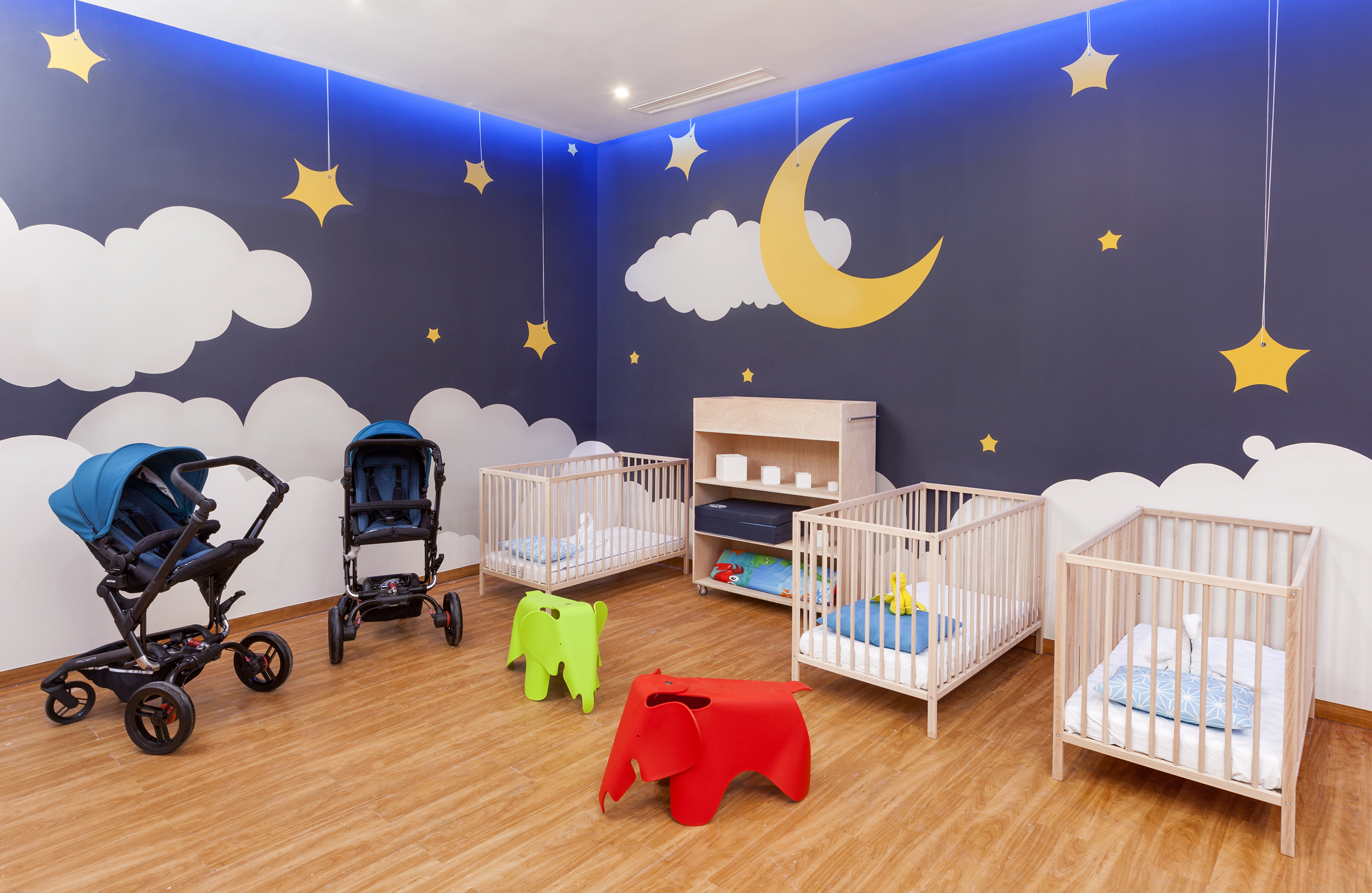 a room with cribs and baby strollers