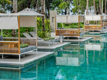 a pool with lounge chairs and umbrellas