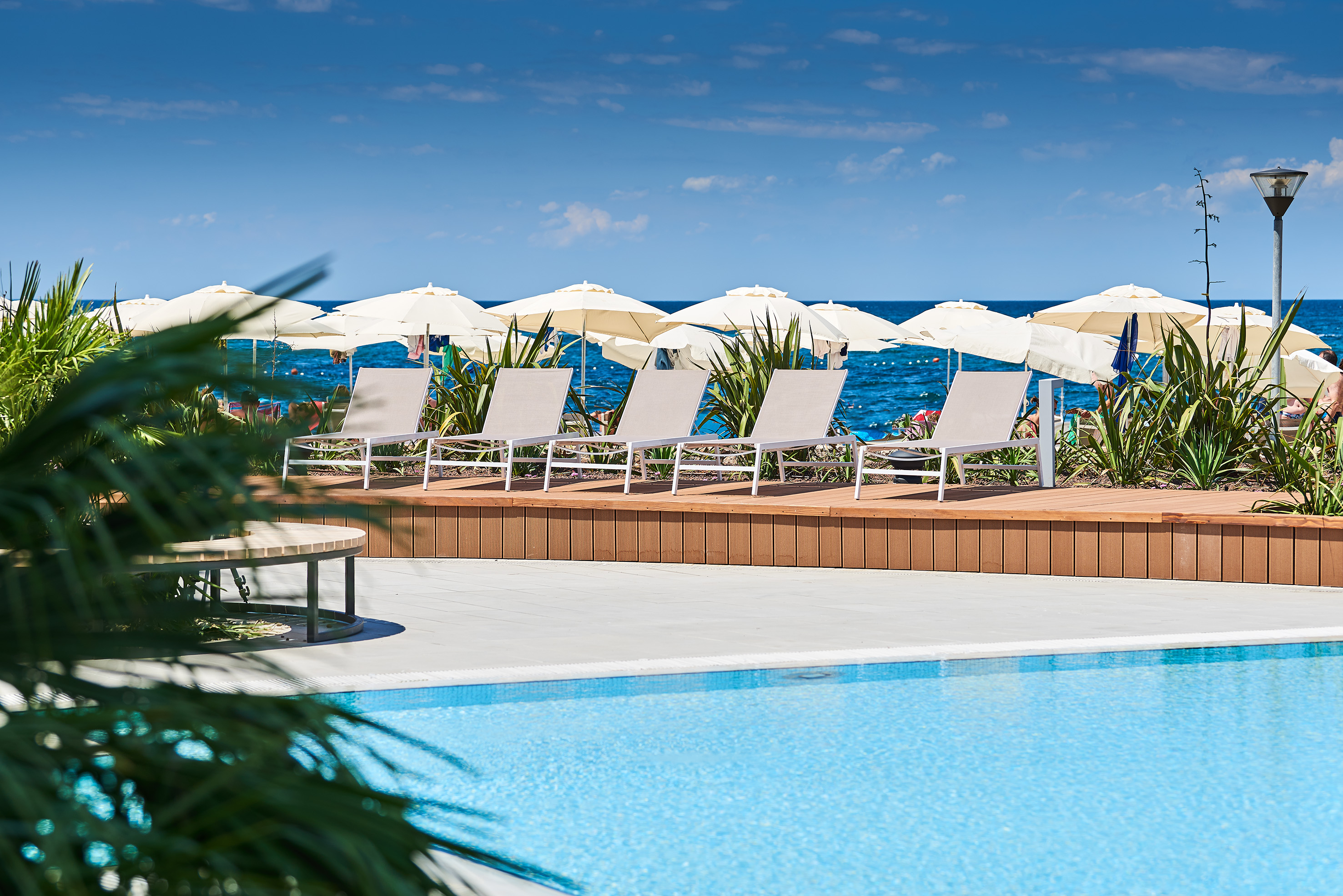 a pool with chairs and umbrellas