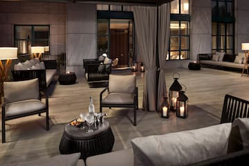 a patio with chairs and tables and candles