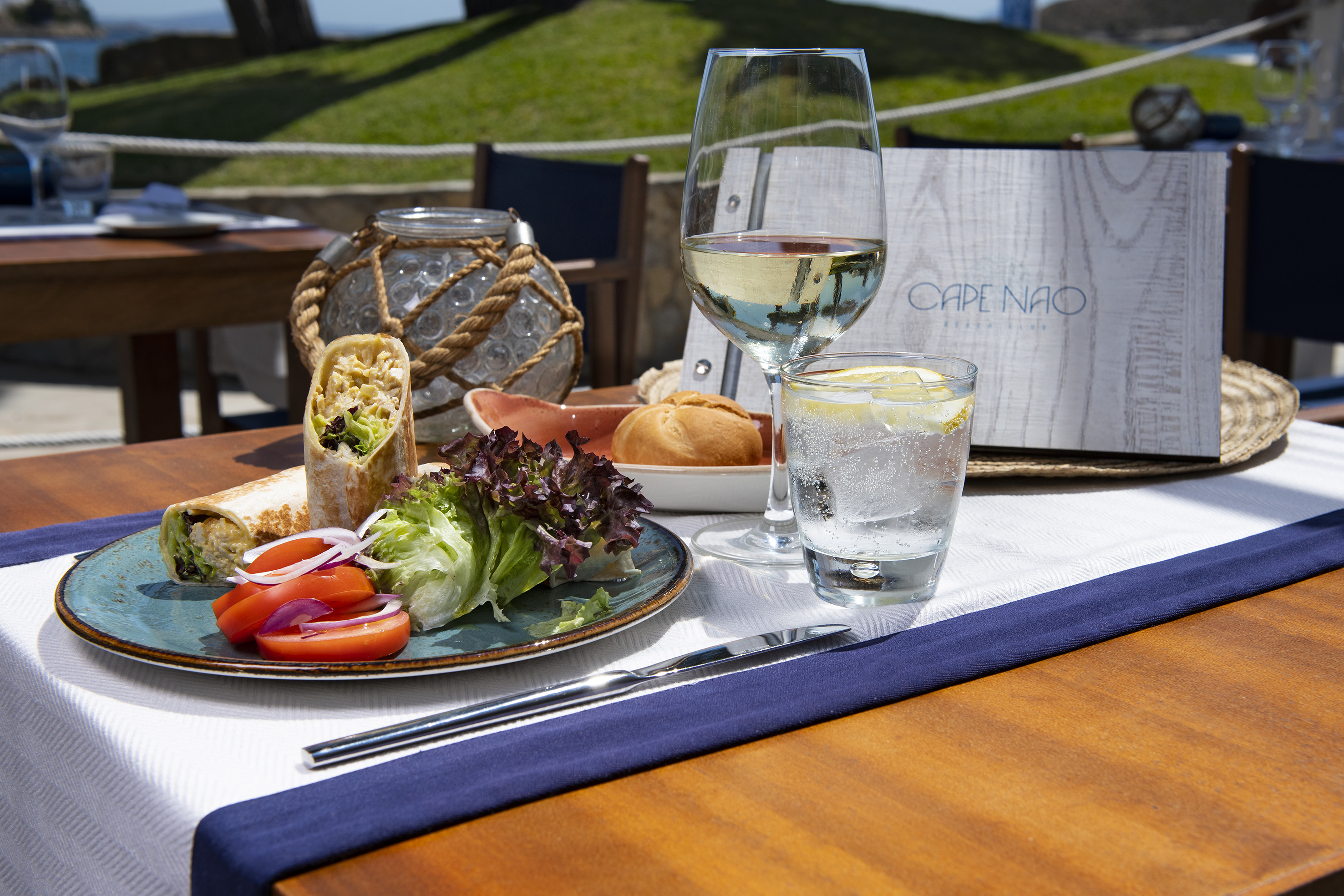 Cape Nao restaurant outdoor lunch: Wrap, fresh salad, wine, sparkling water.