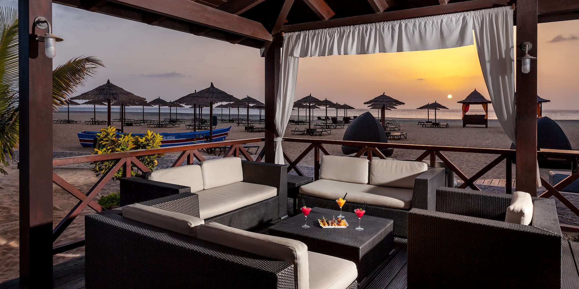 a patio with a table and chairs on a beach