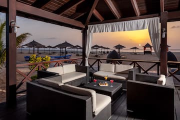 a patio with a table and chairs on a beach