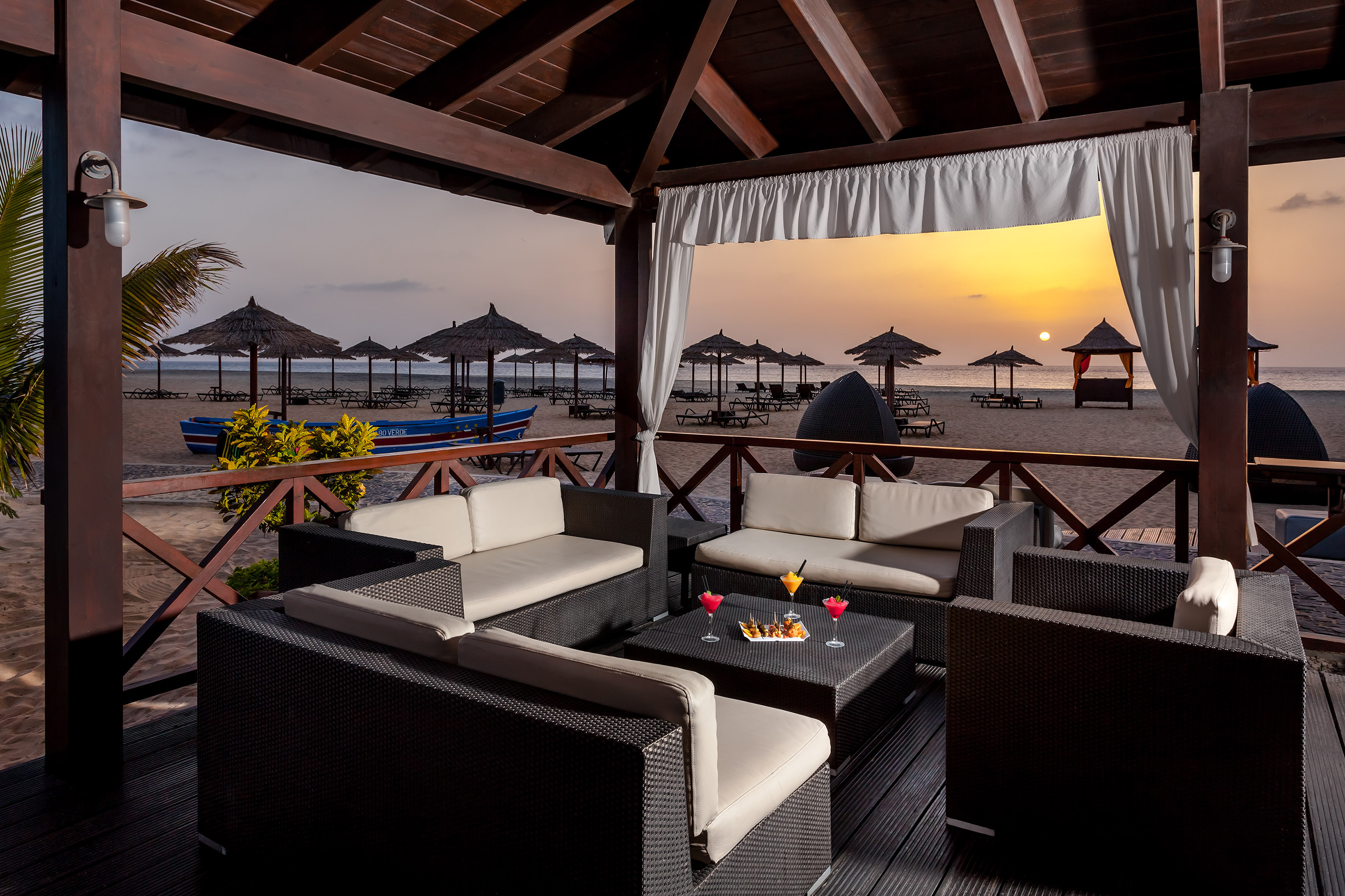 a patio with a table and chairs on a beach