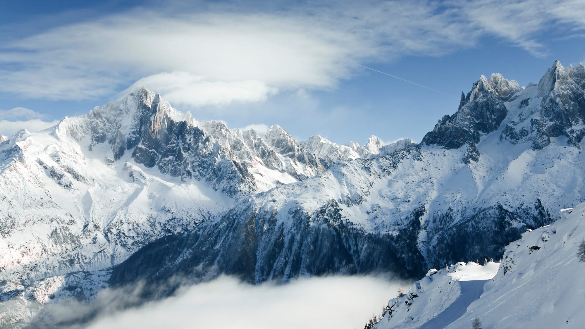 a snowy mountain tops with clouds