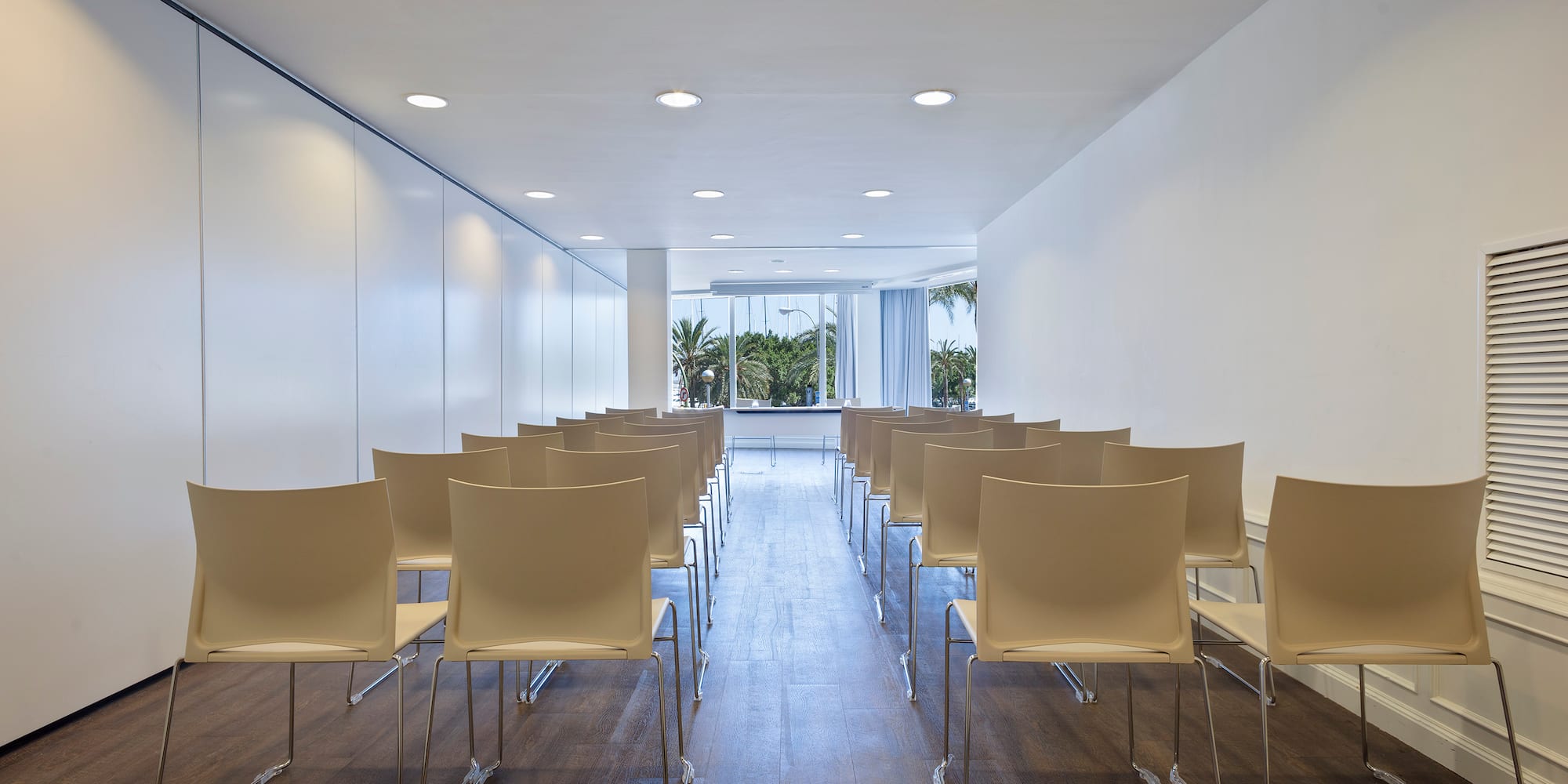 a room with white chairs and a window