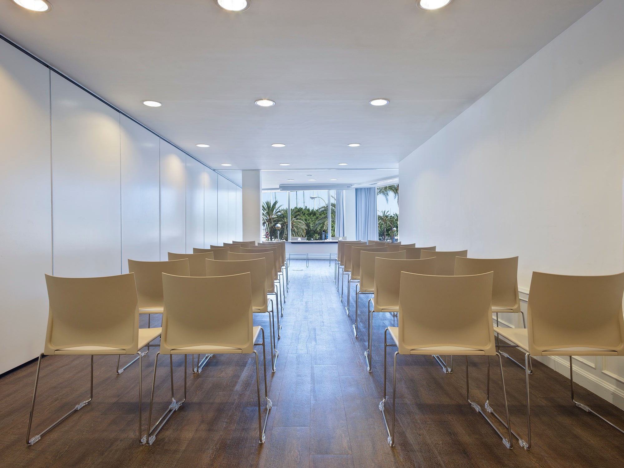 a room with white chairs and a window