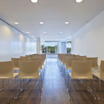 a room with white chairs and a window