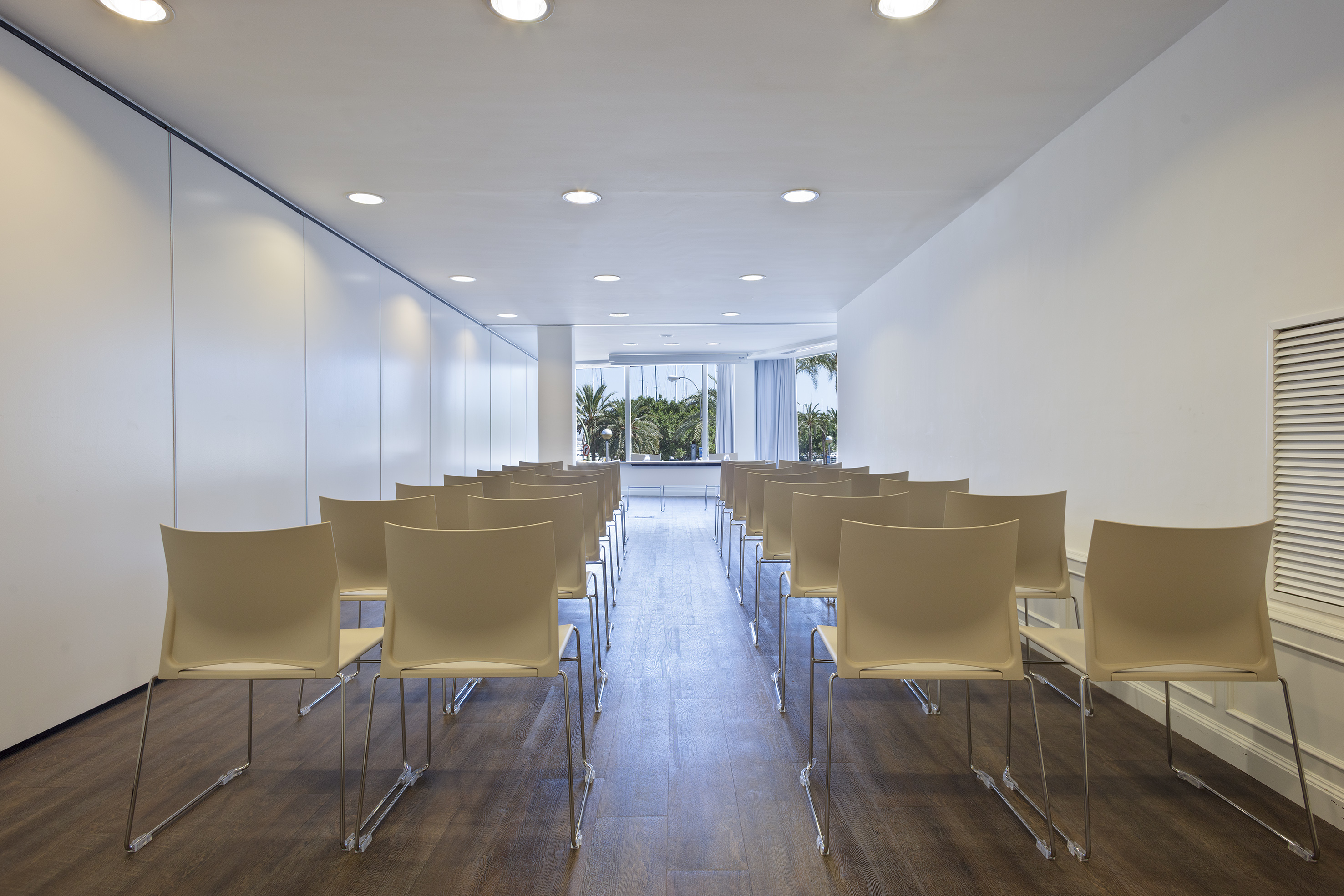 Bright modern conference room with chairs and tropical view.