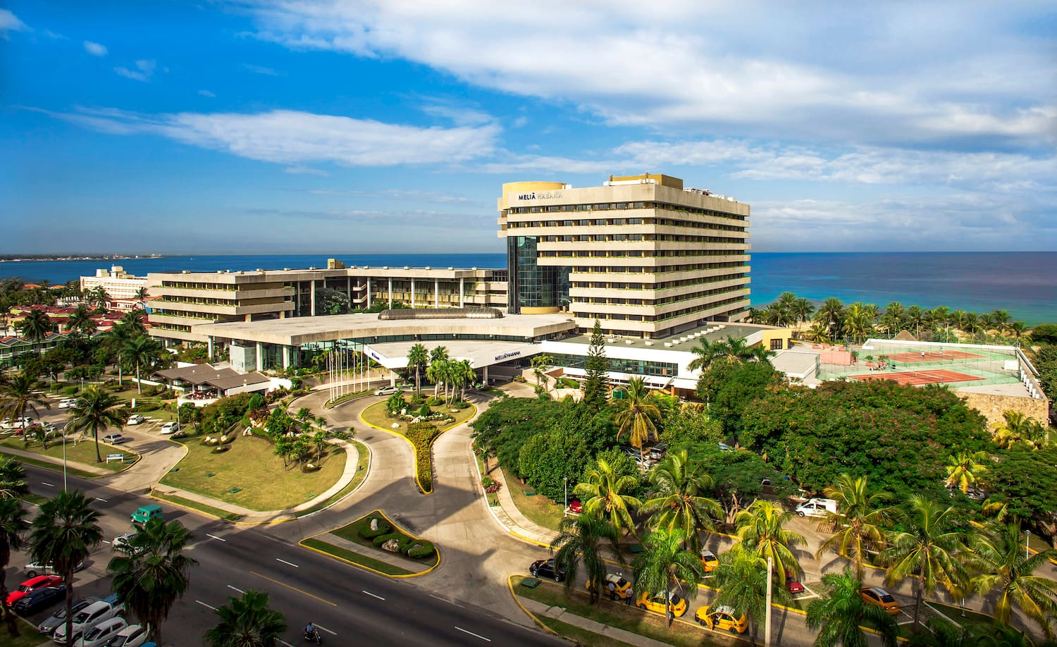 a large building with a road and trees