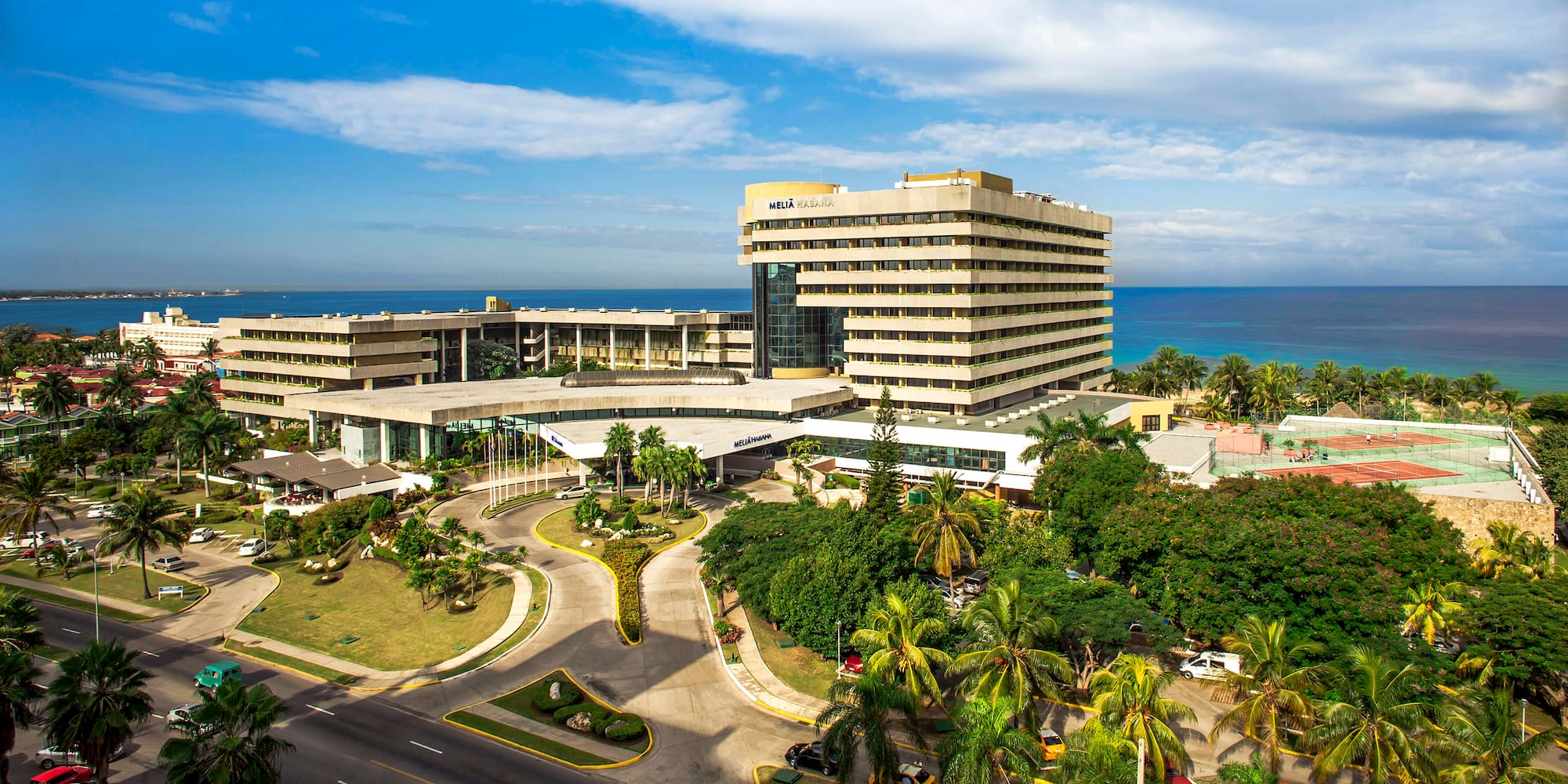 a large building with a road and trees
