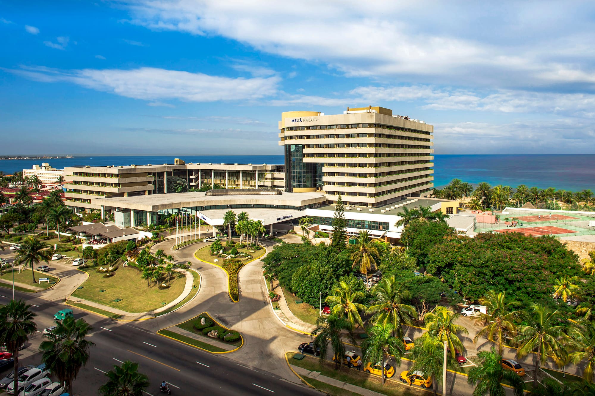 a large building with a road and trees