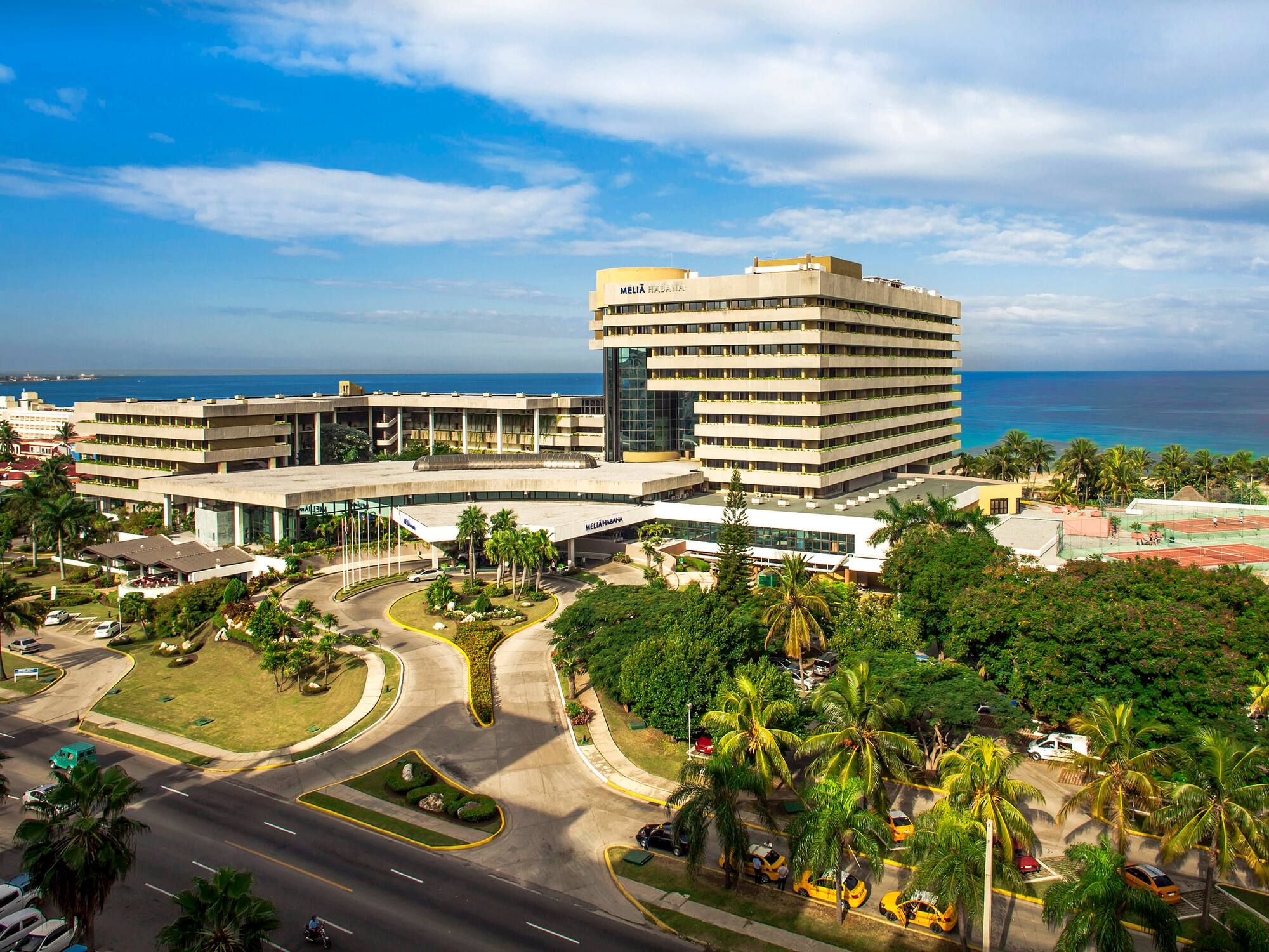a large building with a road and trees