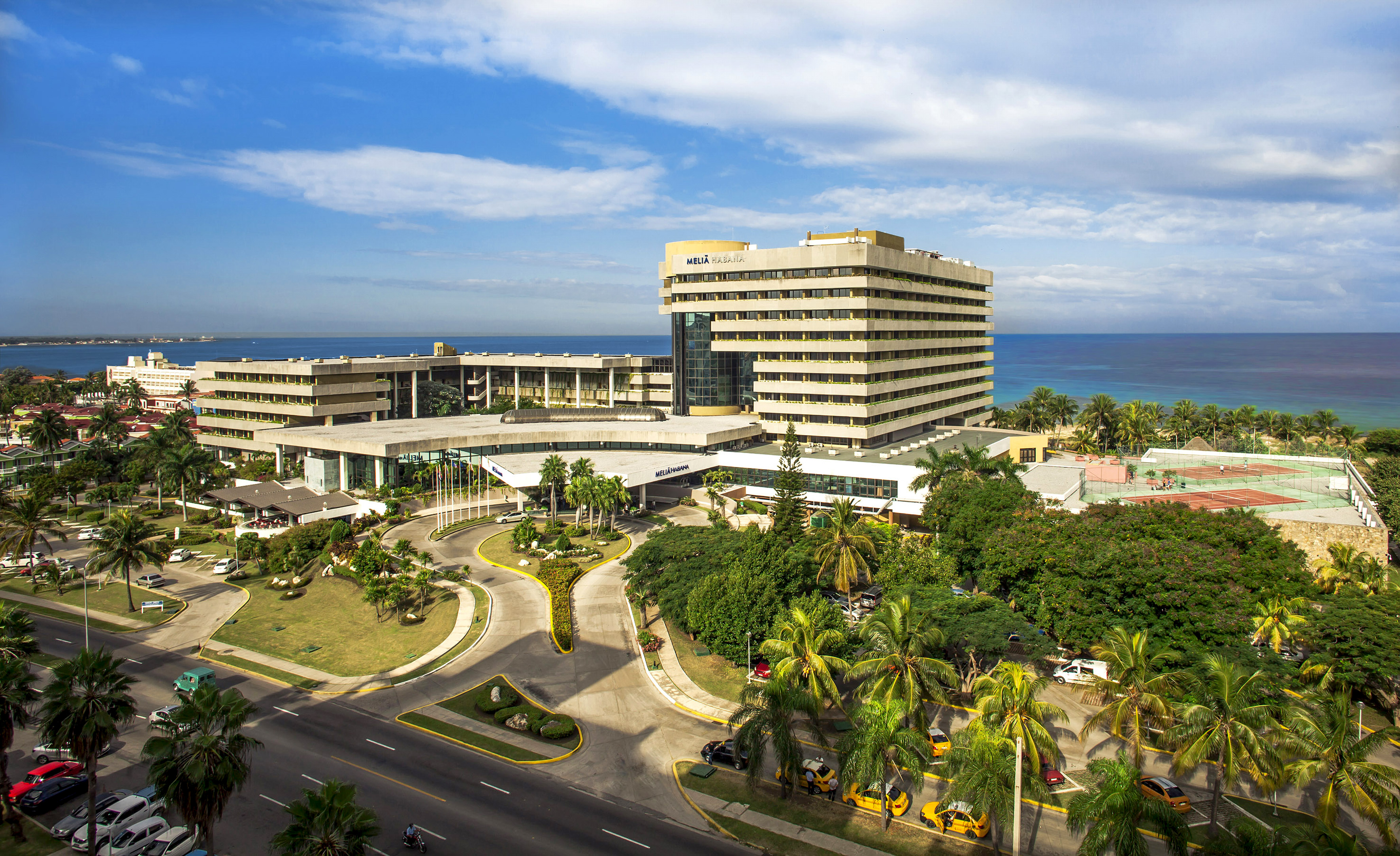 a large building with a road and trees