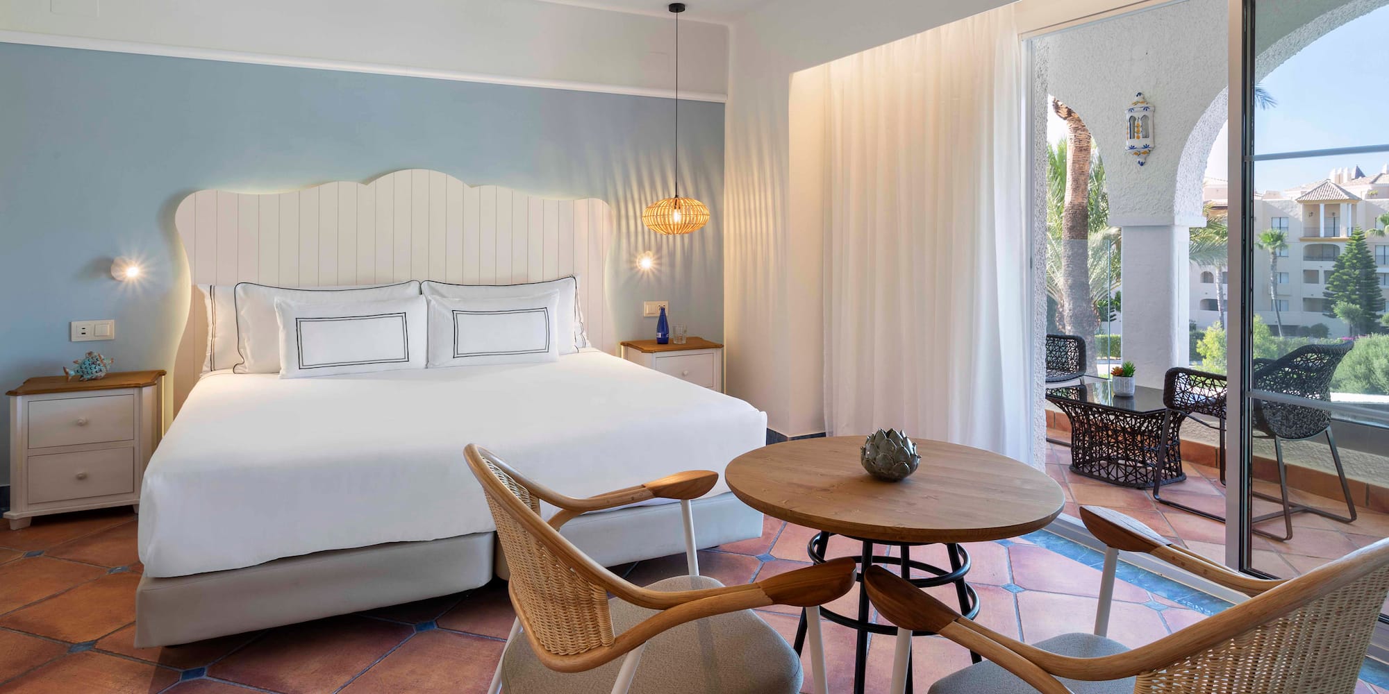 a room with a bed and chairs