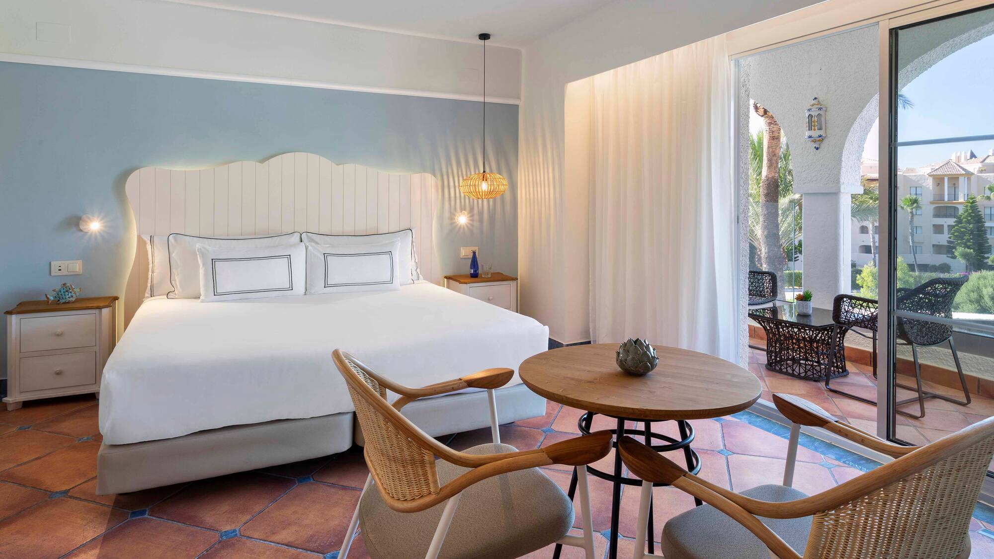 a room with a bed and chairs