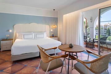 a room with a bed and chairs