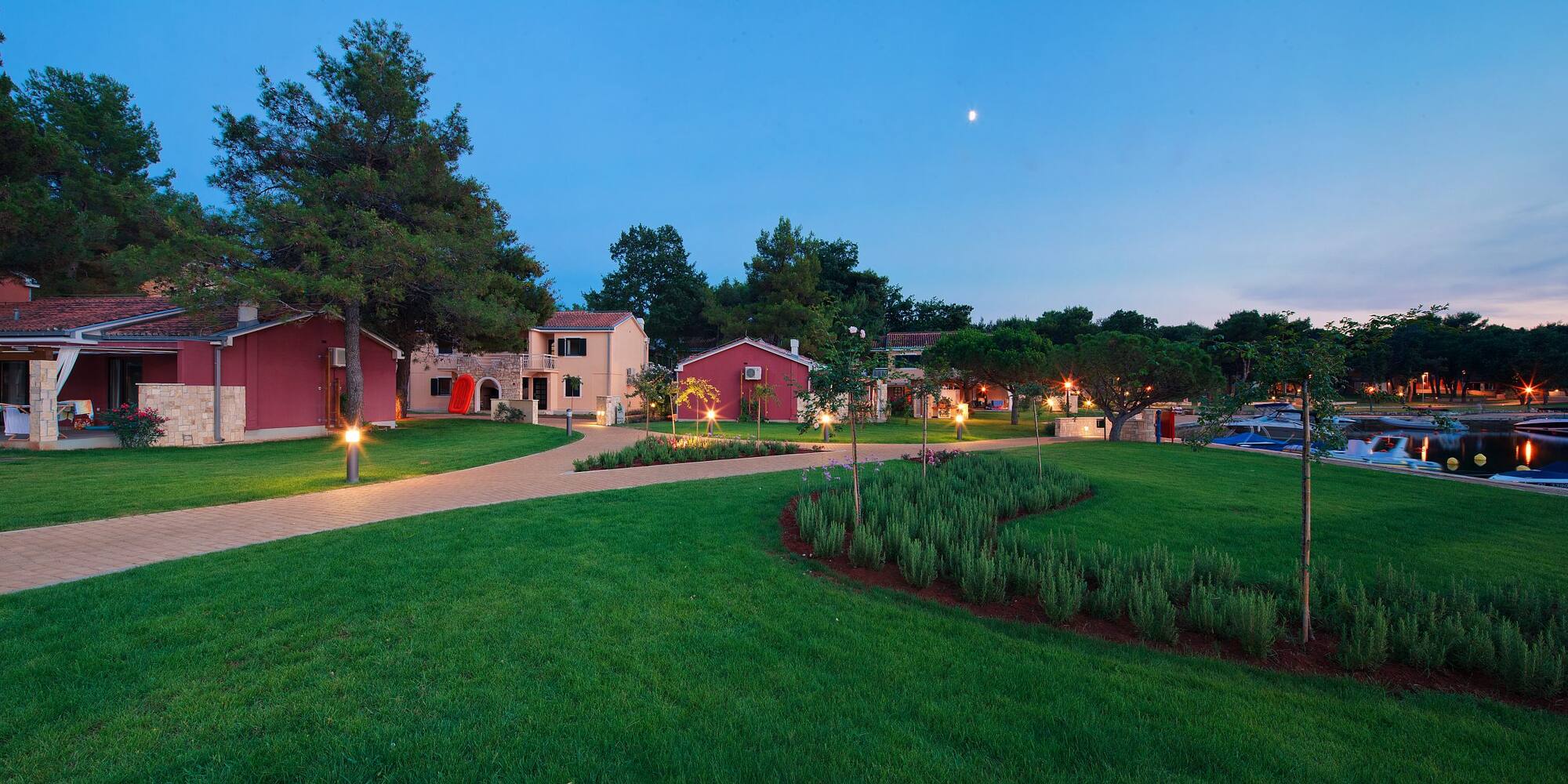 a lawn with trees and houses in the background